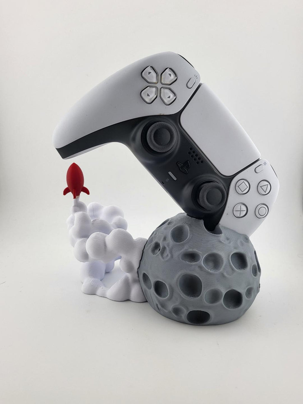 PS5 controller displayed above moon and rocket stand; controller excluded