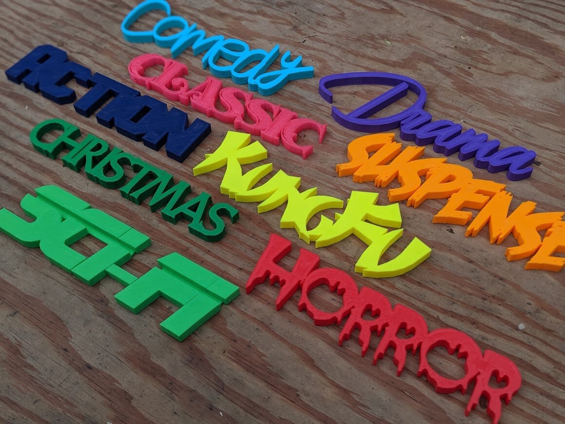 Colorful 3D-printed movie genre sign set on a black background — image 3 of 10