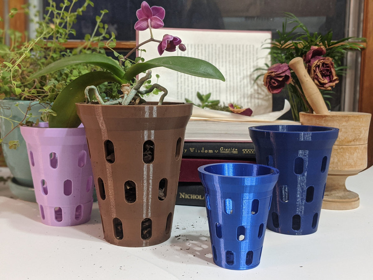 Brown orchid pot with a purple orchid beside purple and blue pot sizes