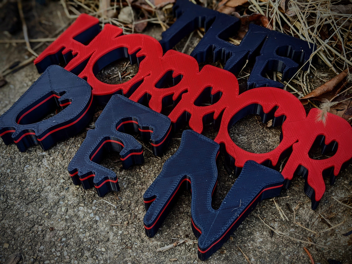Layered red and black Horror Den 3D-printed sign — image 1 of 5