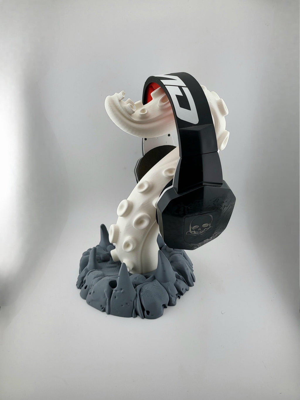 Light tentacle headphone stand with dark gray rocky base holding headphones; headphones excluded