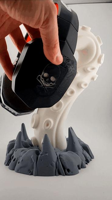Headphones being lifted from the tentacle stand; headphones excluded