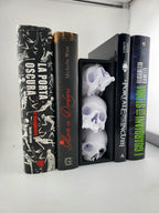 Skull book nook with three pale skulls between books