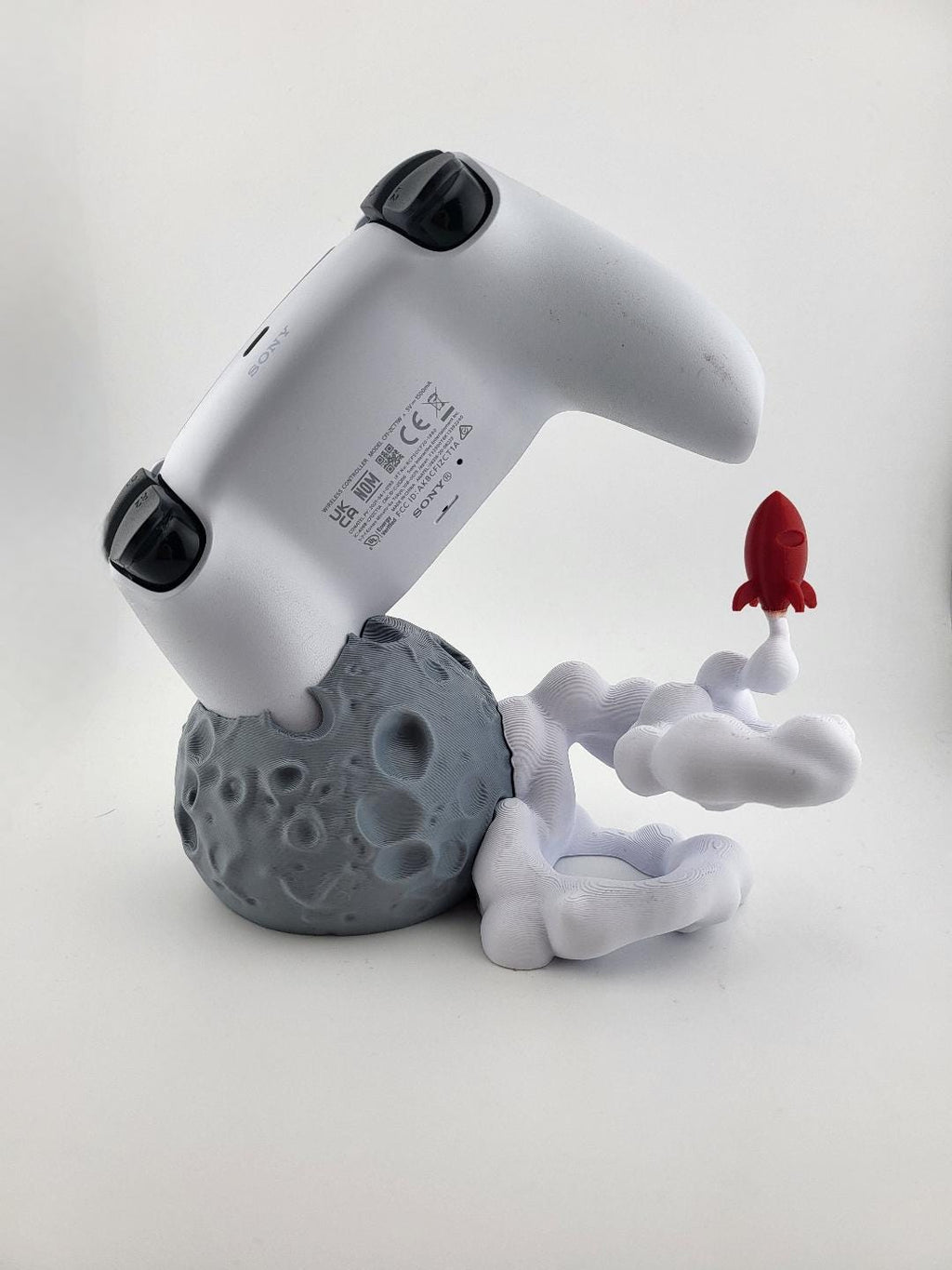Rear view of a PS5 controller on the moon base stand; controller excluded