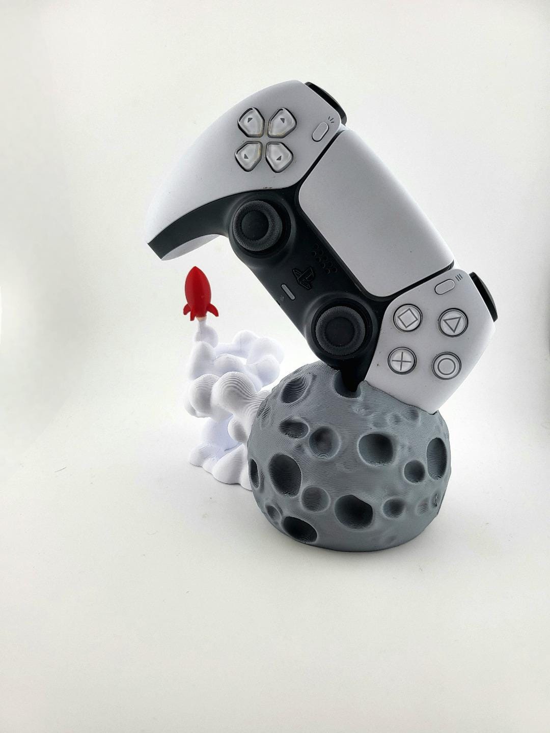 Gray moon base, white smoke and red rocket with controller; controller excluded