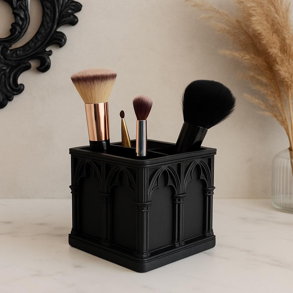 Black Gothic cathedral makeup brush holder with four brushes on a light vanity surface