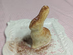 Molded butter figure on a powder-dusted white plate, shown from the opposite side.