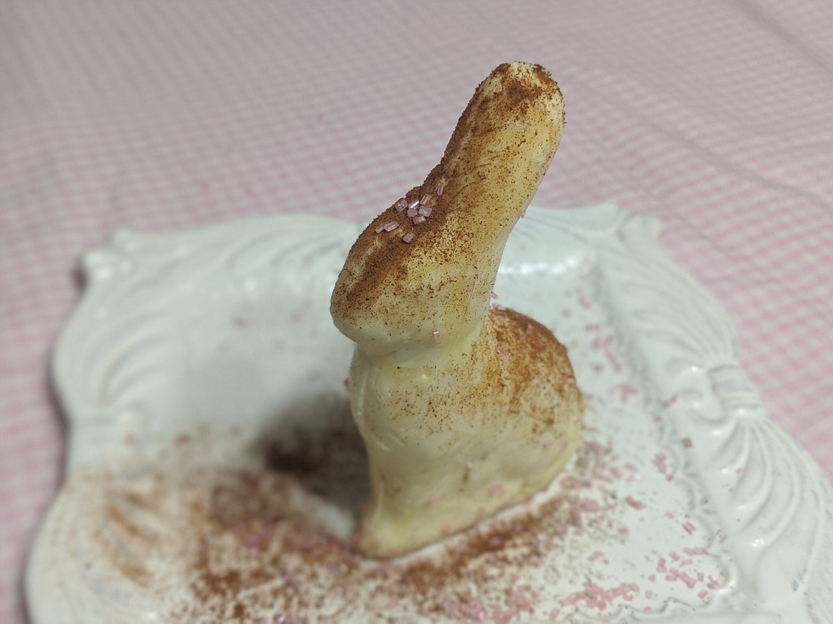 Molded butter figure on a powder-dusted white plate, shown from the opposite side.