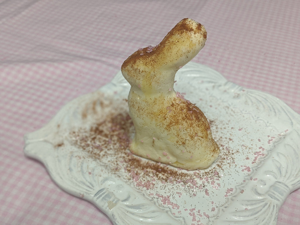 Side view of the molded butter figure standing on an ornate white plate.