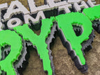 Extreme close view of jagged green Crypt letters, showing elongated drips, layered edges and fine surface lines.